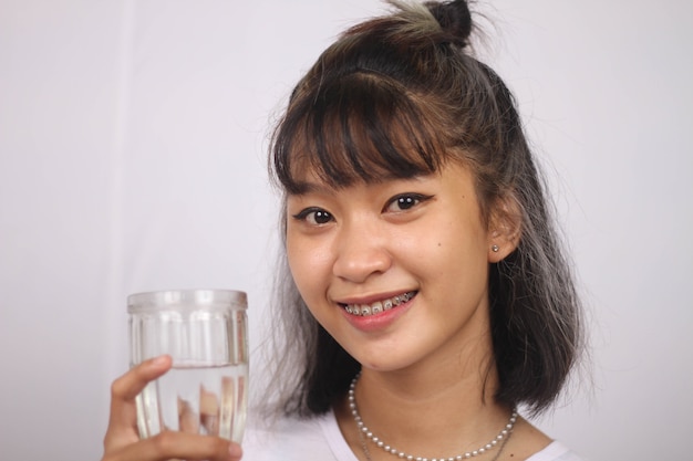 Asian woman holding glass of water on white background isolated