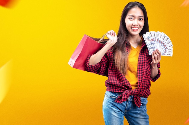 Asian woman holding money and shopping bag with colored background