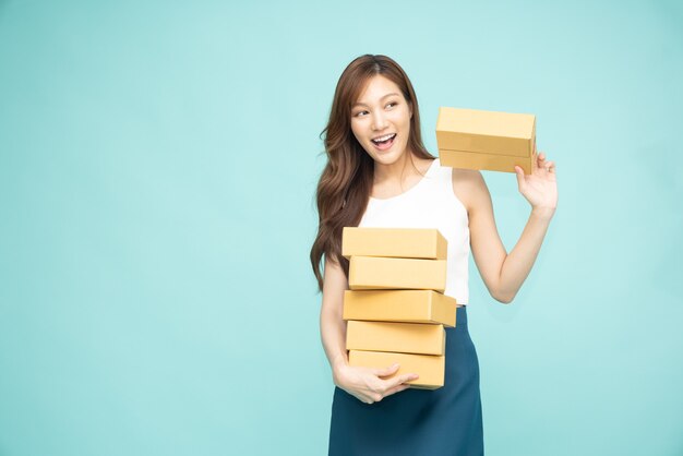 Asian woman holding package parcel box isolated on green background