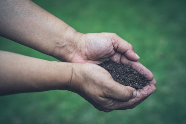 Photo asian woman holding peat moss organic matter improve soil for horticultural plant growing