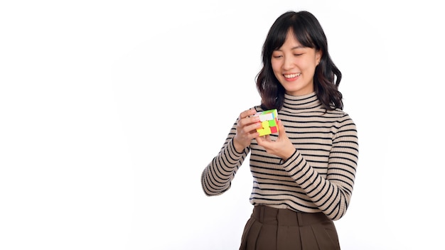 Asian woman holding a puzzle cube standing on white background solving cubic problems problem solution and making strategic moves concept