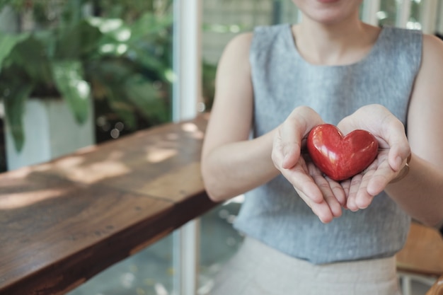 Asian woman holding red heart, health insurance