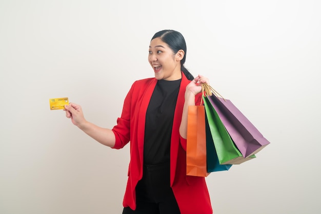 Asian woman holding shopping bag and credit card on hand with white background