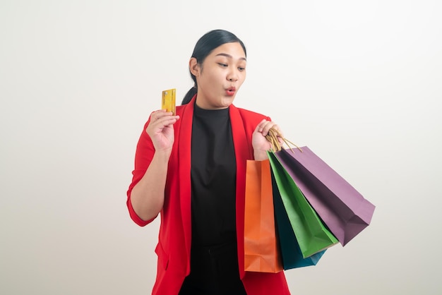 Asian woman holding shopping bag and credit card on hand with white background