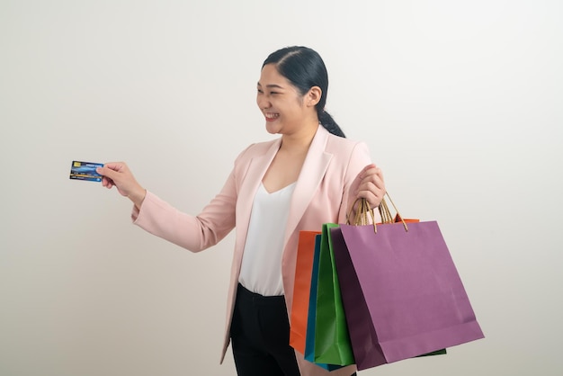 Asian woman holding shopping bag and credit card on hand with white background