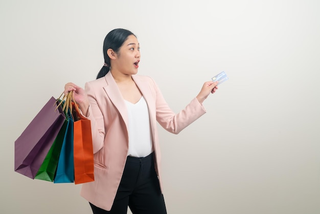 Asian woman holding shopping bag and credit card