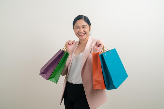 Asian woman holding shopping bag on hand with white background