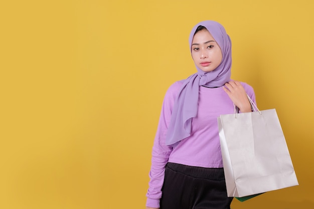 Asian woman holding shopping bag, wearing purple T shirt