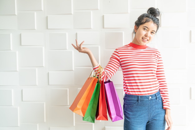 買い物袋を保持しているアジアの女性