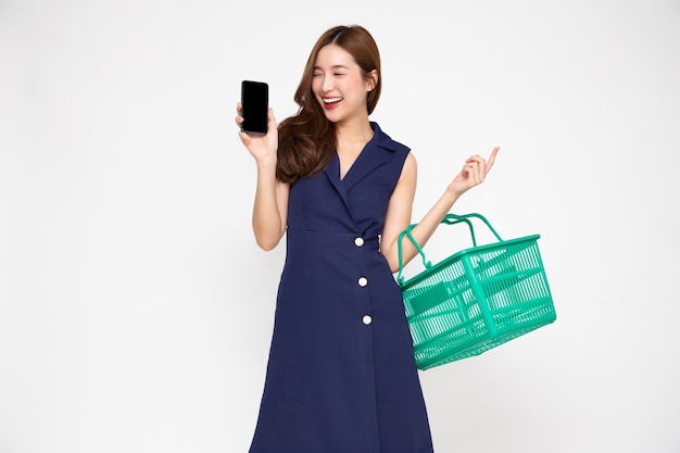 ショッピングバスケットとモバイルを保持しているアジアの女性