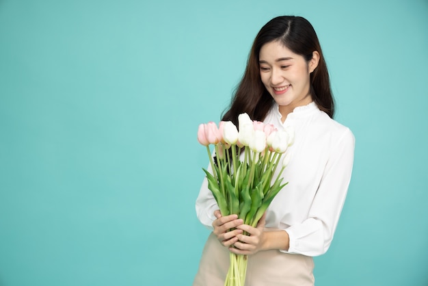 Asian woman holding tulip flower isolated over green surface