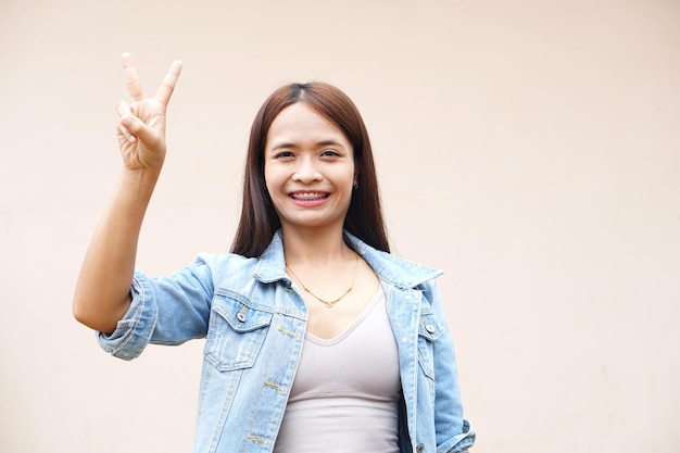 Asian woman holding up two fingers