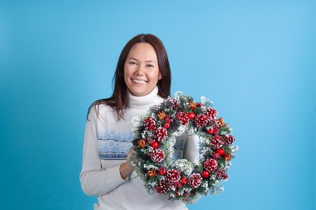 Asian woman holds a Christmas wreath