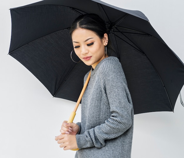 Asian woman holing umbrella on white background