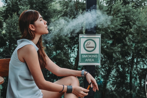 Asian woman inhaling and cigarette vaping Female secretly smoking Concept of quit smoking