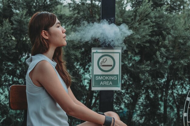 Asian woman inhaling and cigarette vaping Female secretly smoking Concept of quit smoking