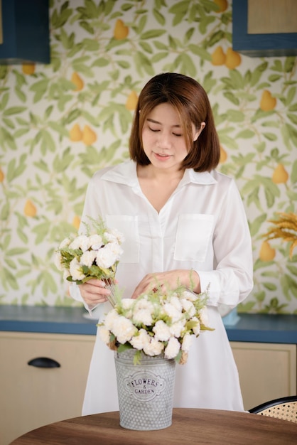 An Asian woman is arranging flowers