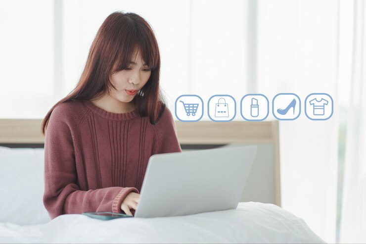 Photo 亞洲女人在床上在她的筆記型電腦上享受網上購物.