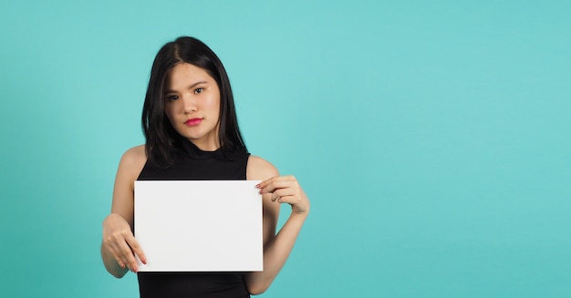 Asian woman is holding blank empty  paper board on green or mint or Tiffany Blue background.