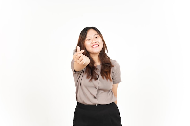 An Asian woman is showing the Korean love sign with a white background smiling brightly