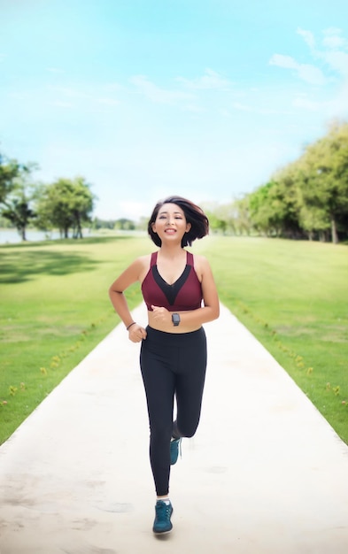 Asian woman jogging in day light at park