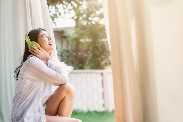 Photo asian woman listening to music from headphone