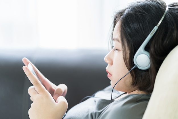 Asian woman listening music from mobile phone