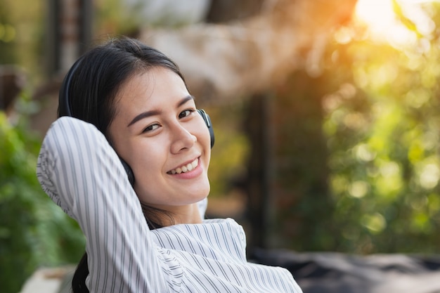 Asian woman listening  to music with relax and happy in free time.