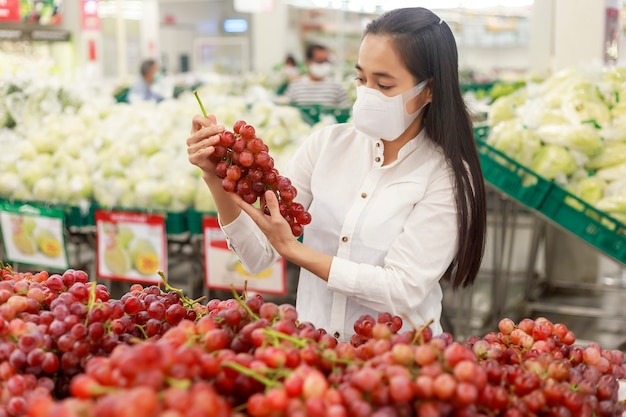 Asian woman long hair wearing protective face mask  in supermarket department store