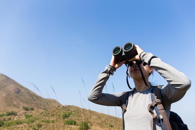 Asian Woman looking though binocular