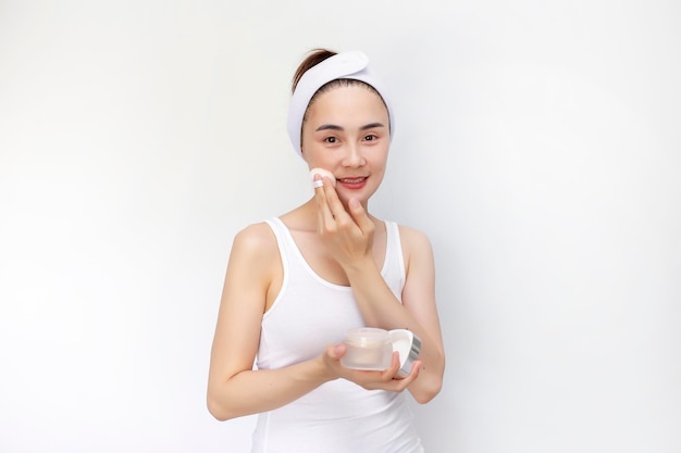 아시아 여성은 트리트먼트 파운데이션 파우더로 얼굴 피부를 화장하고 피부 톤의 차이를 보여줍니다