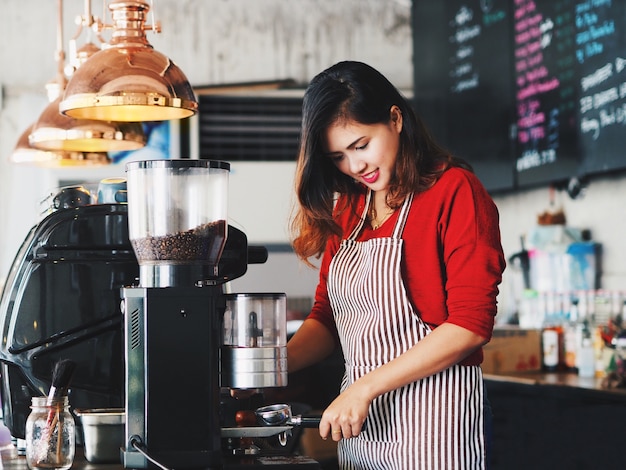 Asian woman making a cup of coffee cup at cafe