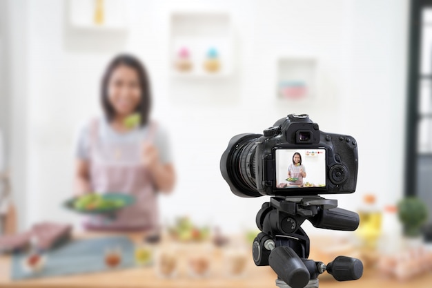 Asian woman making a Vlog video digital camera for her blog cooking in the kitchen room