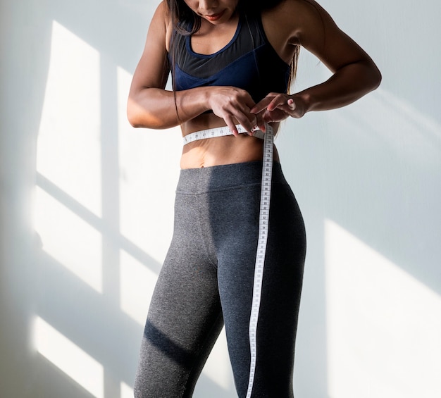 Asian woman measuring waist size