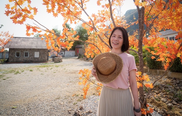 木の下に立って幸せそうに笑っているカメラを見て良い中年のアジア人女性韓国風