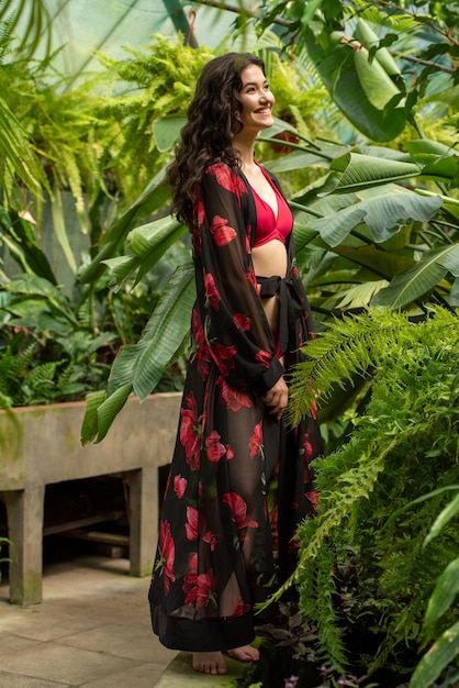 Asian woman near palm trees posing in summer dress on vacation