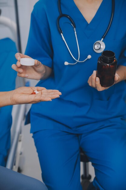 Photo asian woman nurse holding a medicine bottle and telling information to asian senior woman before administering medication caregiver visit at home home health care and nursing home concept