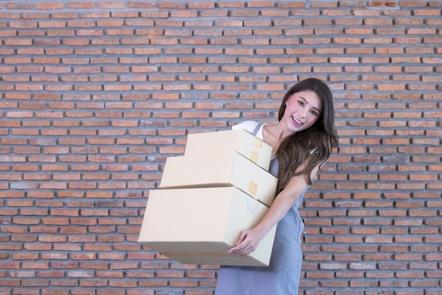 집에서 그녀의 쇼핑 온라인 비즈니스에 소포 상자를 포장하는 아시아 여자