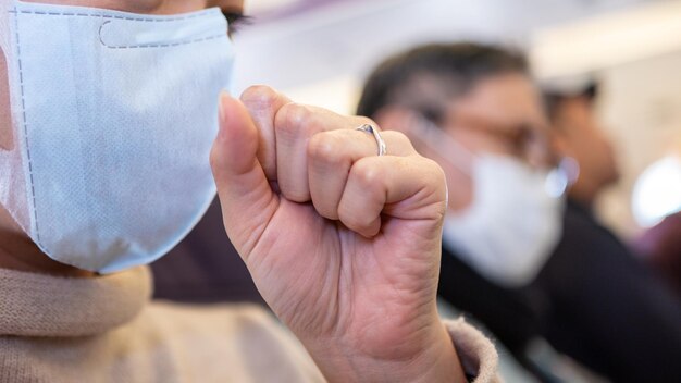 Asian woman passenger coughing over her hand and wearing surgical mask to prevent omicron variant sit down inside the plane Asian person feel sick during flight trip Infection Covid 19 concept