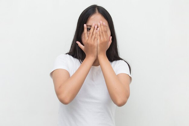 Asian woman peek covers her face with her hands