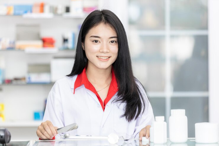 アジアの女性薬剤師が薬局のドラッグストアで錠剤を数えるステンレス鋼のピルカウントトレイを使用して薬局のドラッグストアで患者に薬パックを準備します