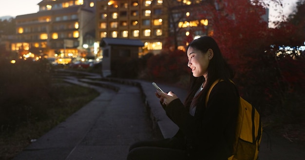 アジア人女性 電話と夜市 ソーシャルメディア コミュニケーションやアウトドア ネットワーキング 女性 遅い夜にモバイルスマートフォンでリラックス ネットチャット 日本の都市部の町