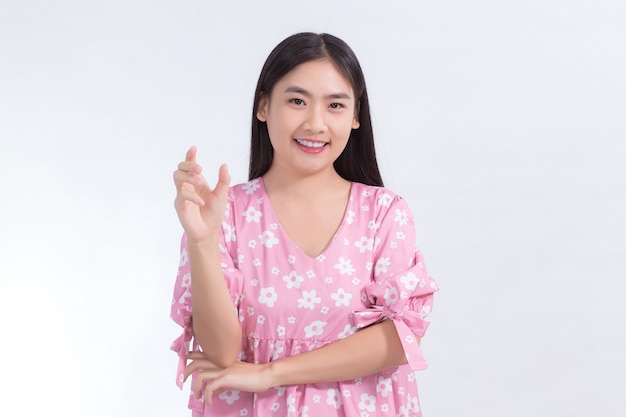 Asian woman in pink dress shows her hand to present or hold something on white background