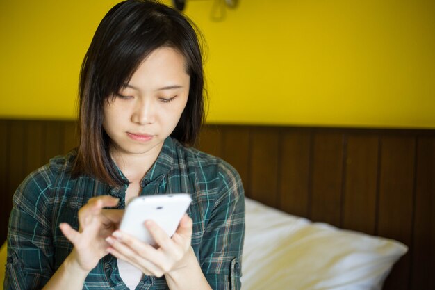 사진 아시아 여성은 집에서 스마트폰을 한다.