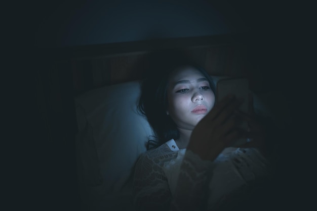 사진 밤에 침대에서 스마트폰으로 게임을 하는 아시아 여성thailand peopleaddict 소셜 미디어