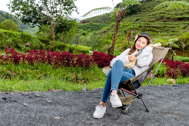 Asian woman playing guitar enjoying camp activity