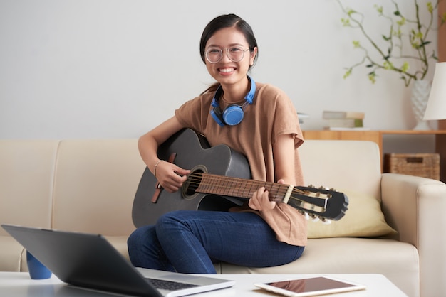 Asian woman playing guitar