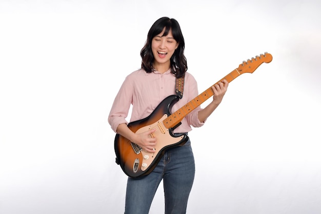 Asian woman playing a vintage sunburst electric guitar isolated on white background