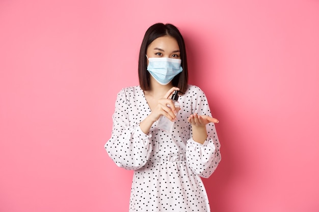 Asian woman pointing fingers at her face mask