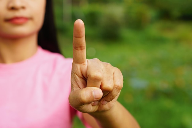 전면의 버튼처럼 손가락을 가리키는 아시아 여성